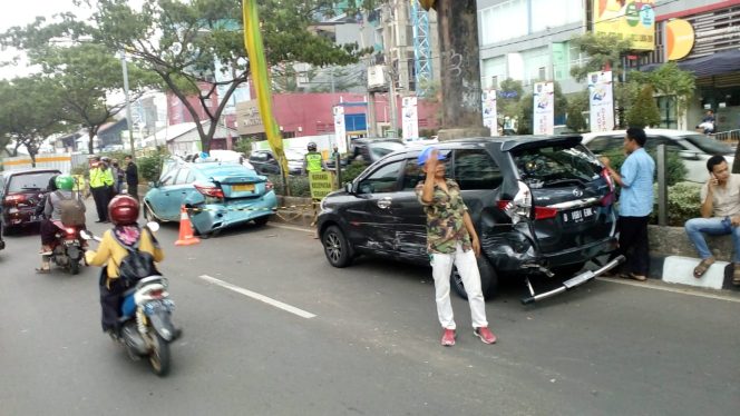 
					Mobil warna silver bernomor polisi B 2159 MB menghantam tiga kendaraan lain yang ada di muka. (FOTO : Harian Sederhana)