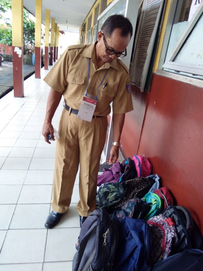 
					Guru sedang mengawasi tas siswa peserta USBN di SDN Pasir Putih 03. (FOTO : Sudibyo/Harian Sederhana)