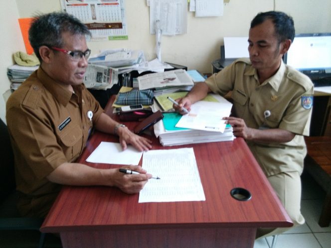 
					Yuyun Purwana, Kasie Ekonomi dan Pembangunan Kelurahan Pondok Petir (kiri) berkoordinasi dengan Gisman Manik, Kasie Pemerintahan dan Tramtib. (FOTO : Sudibyo/Harian Sederhana)