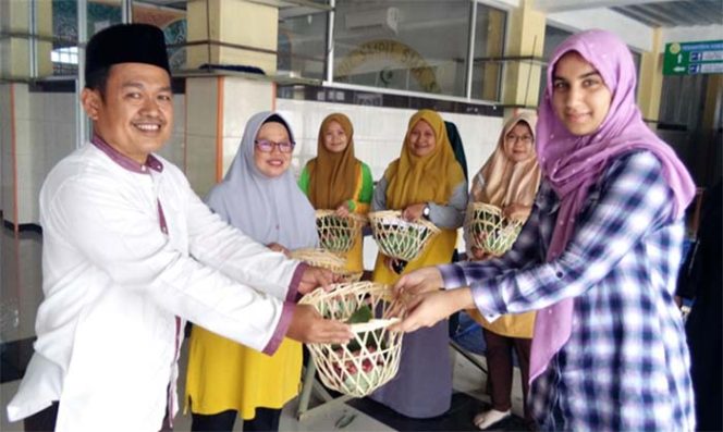 
					Direktur Sekolah AMEC secara simbolis menyerahkan daging kurban kepada Miss Zetty, guru Bahasa Inggris Sekolah AMEC berkebangsaan Kanada.