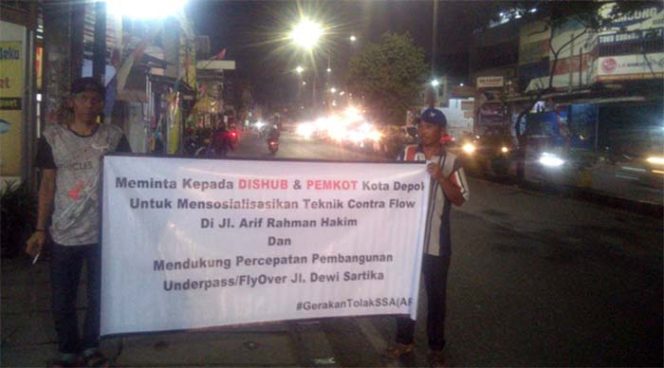 
					Warga Beji membantangkan spanduk meminta Dishub sosialisasi terkait contra flow.