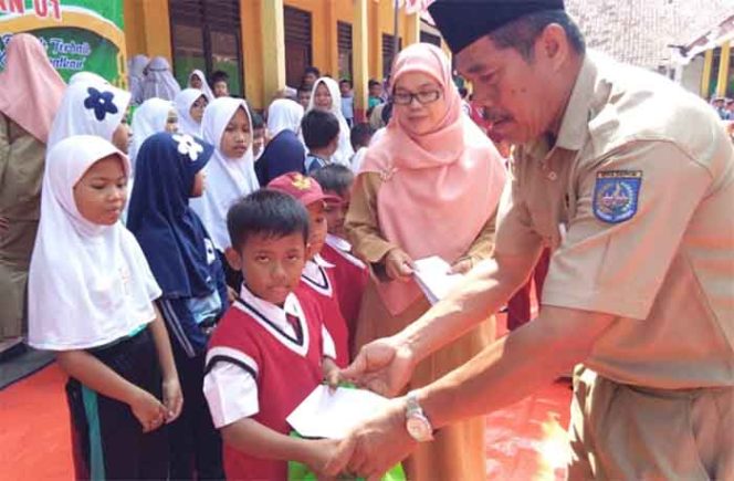 
					Kepala SDN Sawangan 0, Adung Suparman secara simbolis menyerahkan santunan kepada siswa yatim.
