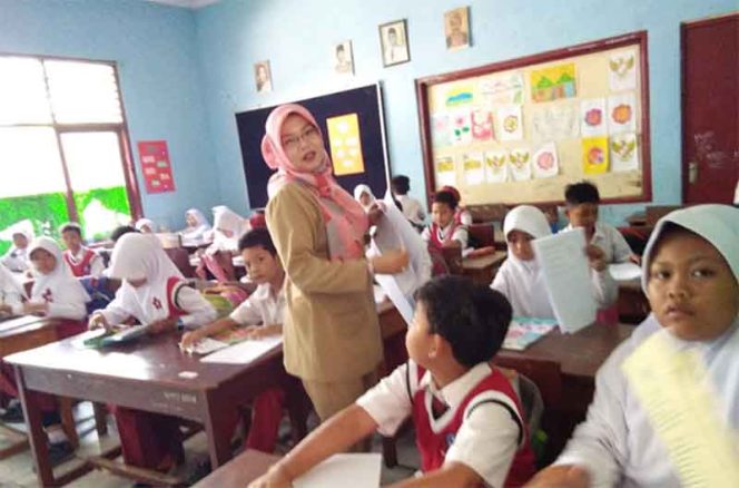 
					Yus Marni, guru kelas 4 tengah memberikan soal pada kegiatan PTS di SDN Sawangan 01.