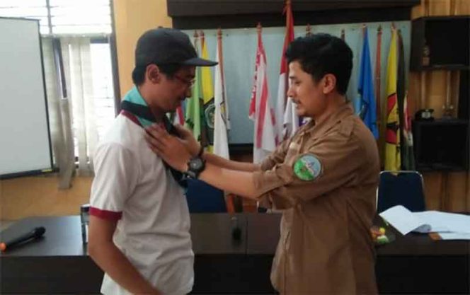 
					Hari Angga Saputra selaku Ketua Satgiat Jurnalis Pramuka tengah dipakaikan selendang.