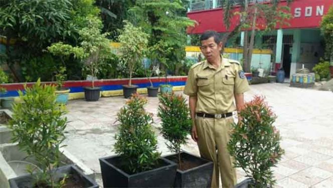 
					Sumarna, Kepala SDN Pondokcina 2 memperlihatkan jenis tanaman hias di halaman sekolah tersebut. Penanaman pohon terkait keikutsertaan dalam Lomba Adiwiyata 2019.