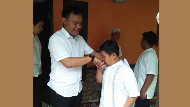 
					Ugi Jarkasih menyerahkan santunan.