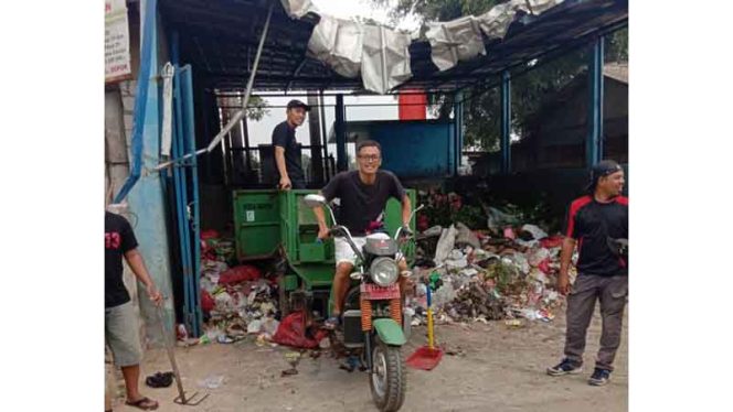 
					Para pemuda membawa sampah hasil kerja bakti ke pembuangan sampah sementara. 