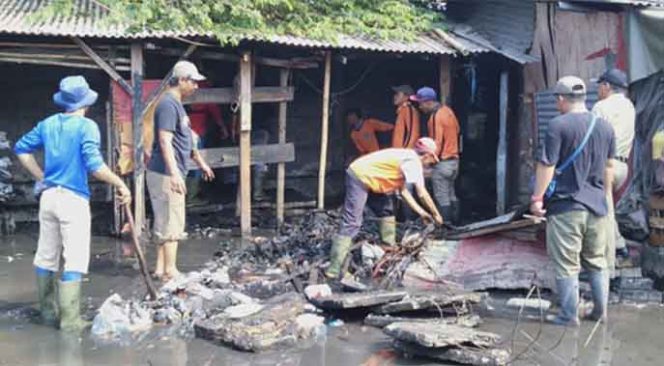 
					Sejumlah petugas Pasar Kemirimuka gotong royong melakukan aksi bersih.