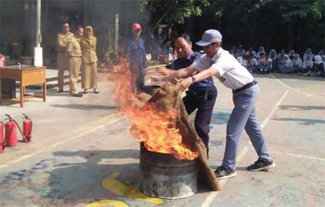 
					Siswa S<A Negeri 8 Kota Bogor bersama petugas pemadam kebakaran melakukan simulasi pemadaman api. 