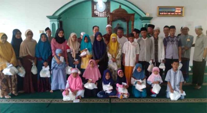 
					Para yatim dan dhuafa di RW 14 menerima santunan.