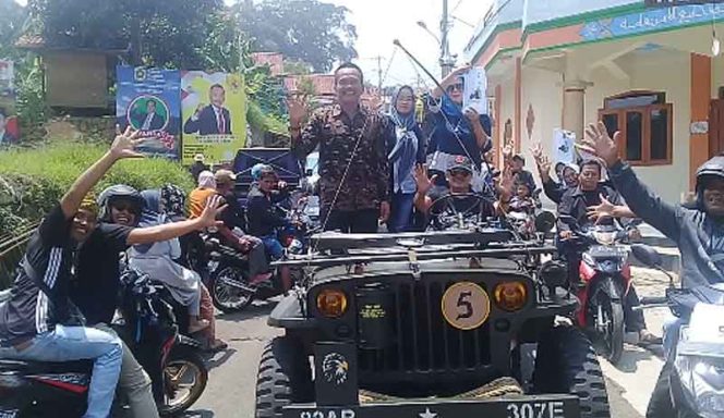 
					Calon Kades Pethana Eman Sulaeman saat menyapa para warga saat diarak pendukungnya.