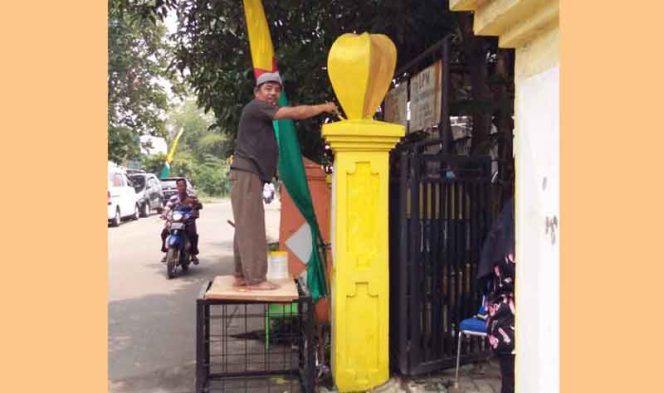 
					Kasie Pemerintahan dan Tramtib Kelurahan Pasir Putih, Tondi Andri sedang mengecat gerbang kelurahan.