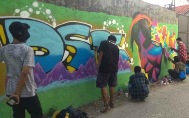 
					Seniman melukis dinding di RW 07, Kelurahan Pondokcina, Kecamatan Beji, Kota Depok. 