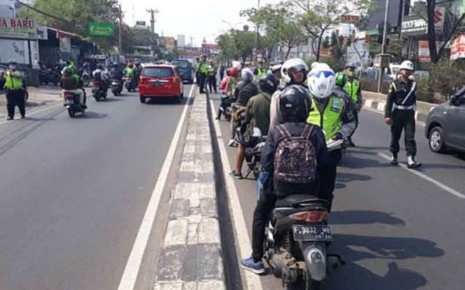 
					Petugas Polres Metrdo Depok sedang memeriksa kelengkapan surat kendaraan.