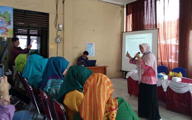 
					Fatmaniar, narasumber sosialisasi RW Ramah Anak sedang memaparkan materi.