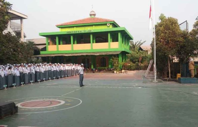 
					Koordinator TU Puskesmas Kranji, Dr. Arie Rahayu Udhani, saat memimpin apel pagi di SMAN 12 Bekasi.