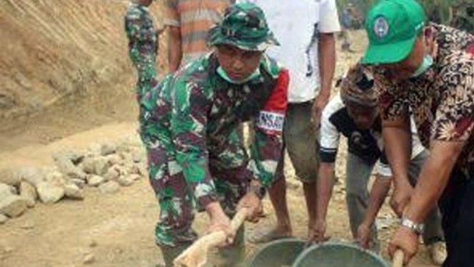 
					Dandim 0621/Kabupaten Bogor Letkol Inf Harry Eko Sutrisno sedang melakukan gotong royong bersama masyarakat di lokasi TMMD