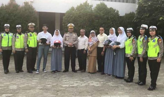 
					Satuan Lalu-Lintas Polresta Depok membagikan helm kepada para pelajar.