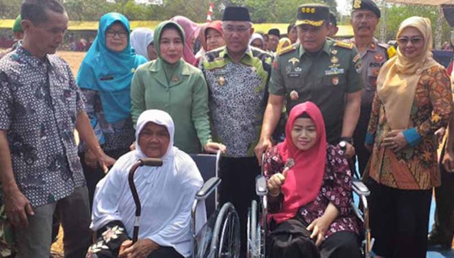 
					Kolonel Inf Agus Isrok Mikroj, Dandim 0508 Kota Depok (tiga kiri) menyerahkan kursi roda kepada warga.