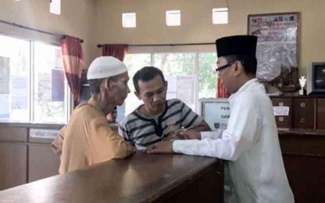 
					Staf di Kelurahan Tugu, Kecamatan Cimanggis mengenakan pakaian muslim saat memberikan pelayanan. 
