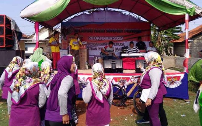 
					Warga RW 03, Kelurahan Ratujaya sedang mendengarkan pengumuman hadiah door prize yang akan dibagikan panitia.