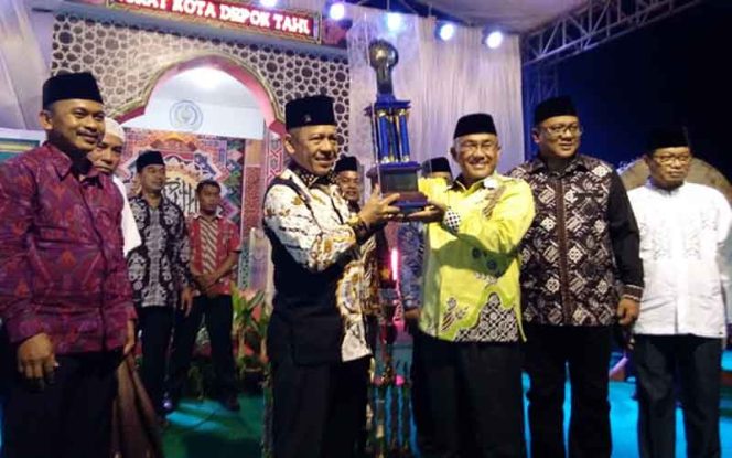 
					Wali Kota Depok, Mohammad Idris menyerahka piala bergilir kepala Camat Sawangan, Herry Restu Gumliar (dua kanan) setelah dinobatkan sebagai juara umum MTQ Ke-XX tahun 2019 di Lapangan Perumahan Sawagan Permai, Kelurahan Putih, Kecamatan Sawangan pada Jumat (1/11) sekitar 20.00 WIB.