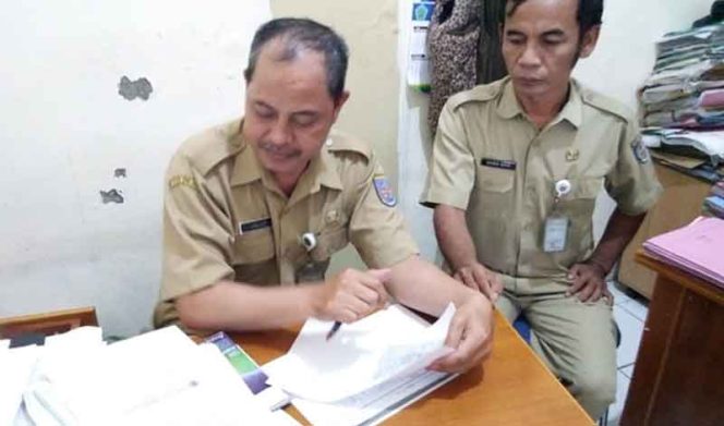 
					Gisman Manik, Kasie Pemerintahan dan Tramtib (kanan) bersama Tarojih, Staf Kelurahan Pondok Petir sedang memeriksan pendapatan PBB 2019.