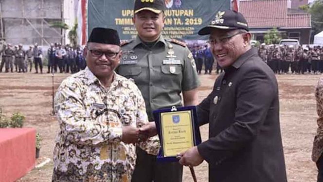 
					Lurah Sukamaju Baru menyerahkan tanda penghargaan kepada Walilota Depok Mohammad Idris atas dukungannya dalam kegiatan TMMD Imbangan Kodim Depok di wilayahnya, Kamis (31/10/2019)