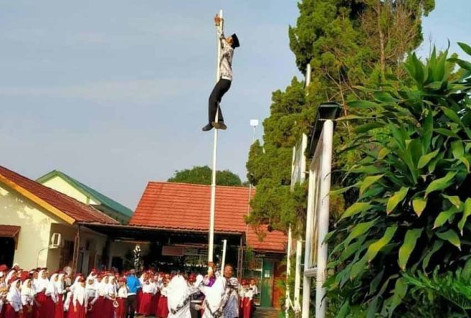 
					Seorang guru di Depok memanjat tiang bendera saat upacara bendera.