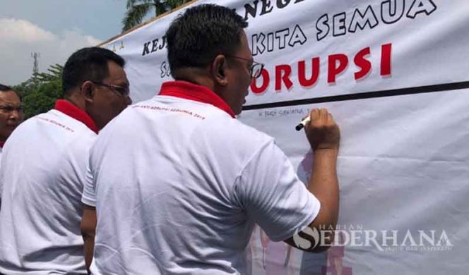 
					Wakil Wali Kota, Pradi Supriatna (kanan) menulis di kain putih ajakan cegah korupsi dalam acara peringatan  Hari Anti Korupsi Internasional (HAKI) di Kejaksaan Negeri (Kejari) Kota Depok.