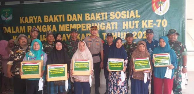 
					Warga foto bersama usai mendapatkan sembako dalam kefiatan Baksos Kodam Jaya di Pasar Cisalak, Depok, Jum'at (20/12/2019).