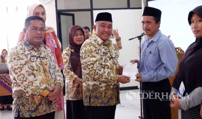 
					Walikota Depok Mohammad Idris saat menyerahkan rekening BJB penerima bantuan RTLH kepada warga Cipayung, Depok.