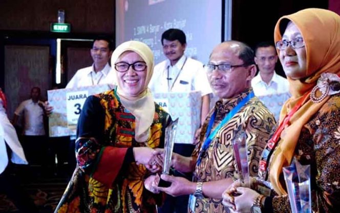 
					Kadisdik Provinsi Jawa Barat, Dewi Sartika saat menyerahkan piala di acara Forum Expose Program Penjaminan Muru Pendidikan.