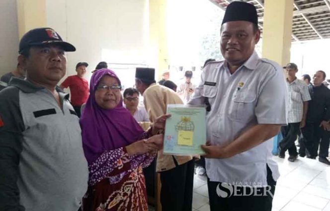 
					Lurah Pasir Putih, Ahmad Rifai secara simbolis menyerahkan sertifikat PTSL kepada warga pemohon.