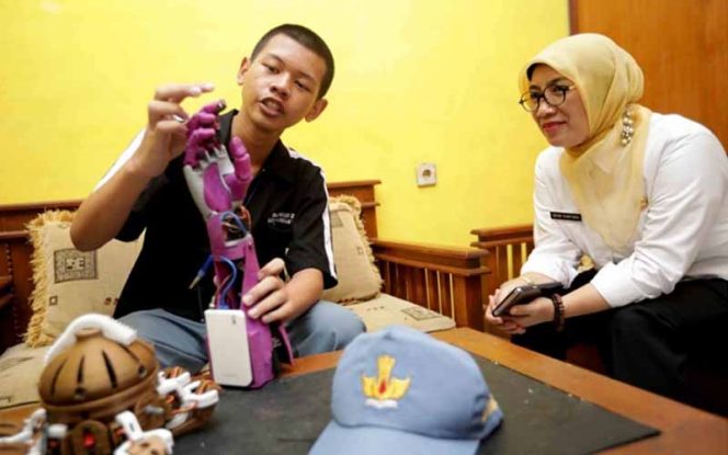 
					Alwan, siswa kelas X SMK 2 Kota Tasikmalaya memperlihatkan alat ciptaannya kepada Kadisdik Jabar, Dewi Sartika.