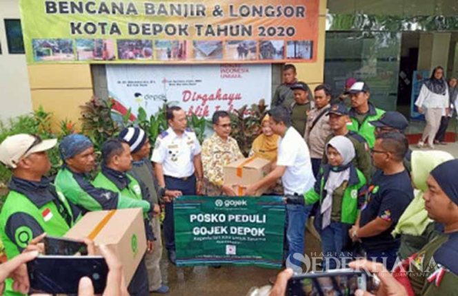 
					District Operation Manager Gojek Depok, Adi Setiadi menyerahkan bantuan bagi korban terdampak banjir dan longsor yang diterima Kadinsos, Usman Haliyana.