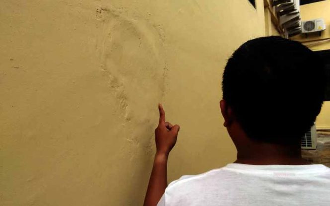 
					Salah seorang warga menunjukkan tambalan acian yang masih kasar di bagian dinding bekalang.