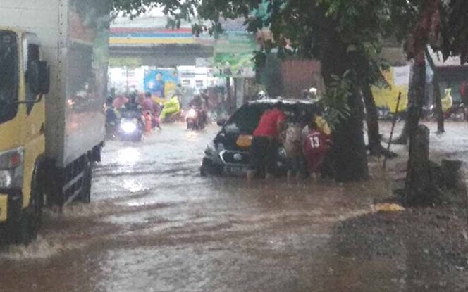 
					Sebuah kendaraan terperosok di lokasi banjir Jalan KSU Parung Serab, Kelurahan Tirtajaya, Kecamatan Sukmajaya, Kota Depok.