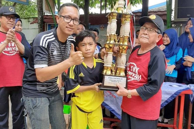 
					Ketua Yadami, AS Tatang (kanan) menyerahkan piala bergilir kepada SDN Serua 03 setelah menang di final melawan SDN Serua 02.