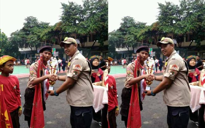 
					Kepala Humas SMPN 33 Kota Bekasi, Petrus membagikan piala kepada anak didiknya.