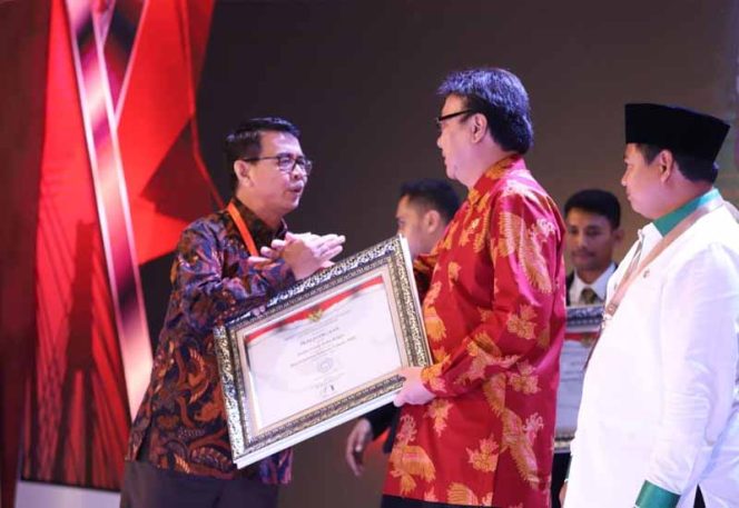 
					Menpan RB Tjahjo Kumolo menyerahkan penghargaan kepada Sekda Kota Bogor, Ade Sarip Hidayat di Raddison Golf & Convention Center Batam, Kota Batam.