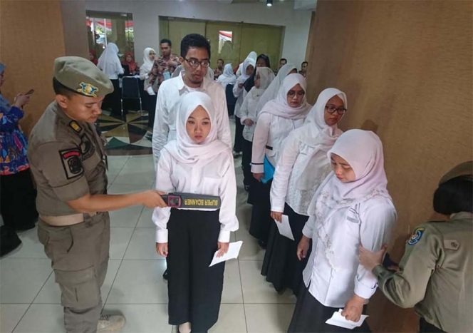 
					Para peserta yang mengikuti tes Seleksi Kompetensi Dasar saat memasuki ruangan ujian, akan diperiksa oleh mesin detektor logam oleh Satpol PP.