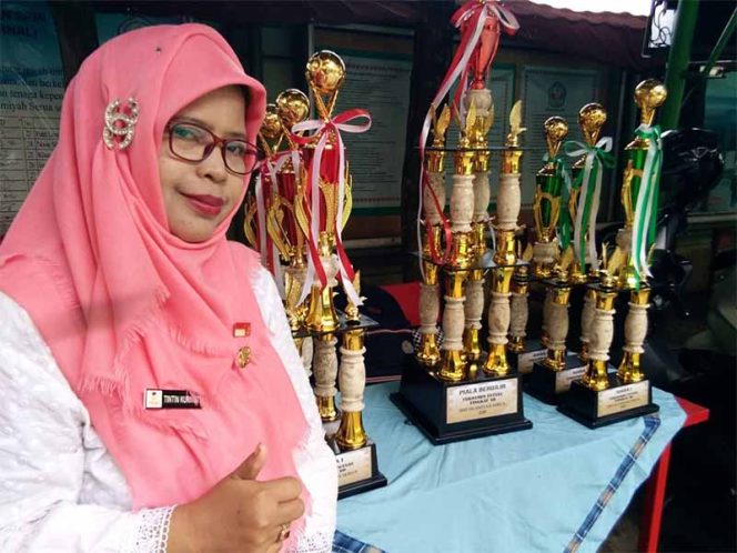 
					Salah satu Kepala SDN di Bojongsari pose dekat piala di Turnamen Futsal Yadami.