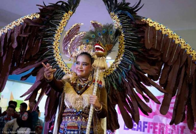 
					Salah satu siswa SLB mengenakan pakaian bersayap. 