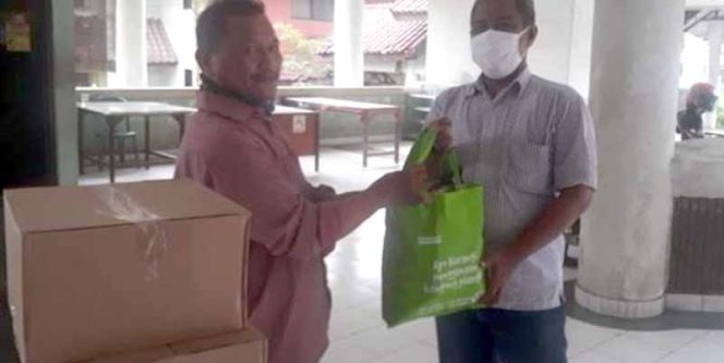
					Budi Santoso menyerahkan bantuan berupa Hand Sanitizer dan cairan Disinfektan ke PWI.