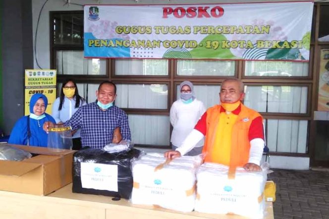 
					Arif Rahman Hakim (baju kotak biru), pasien pertama yang sembuh dari virus corona (Covid-19) memberikan sumbangan APD.