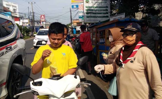 
					Pengendara motor yang tidak menggunakan masker di depan Puskesmas Sawangan diberikan masker.