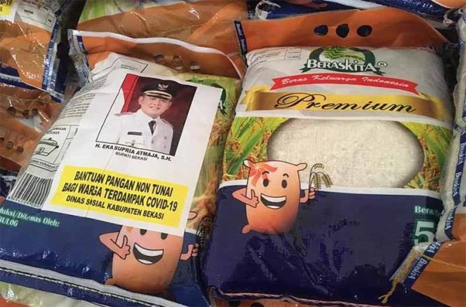 
					Pengadaan stiker foto Bupati Eka Supria Atmaja yang ditempel pada kemasan bantuan sosial (bansos) Pemerintah Kabupaten (Pemkab) Bekasi oleh Dinas Sosial bekerjasama dengan pihak ketiga, semakin ramai dibicarakan di kalangan stakeholder serta elemen masyarakat.