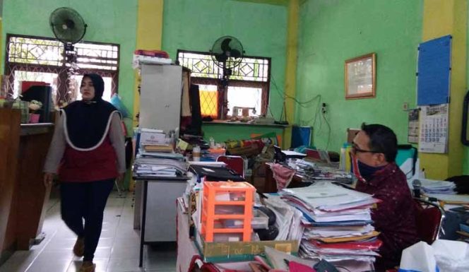 
					Kepala SMP Islamiyah Serua, Hidayat bersama para guru piket di ruang kerjanya.