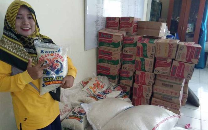 
					Salah satu staf kelurahan memperlihatkan beras di lumbung yang siap didistibusikan.